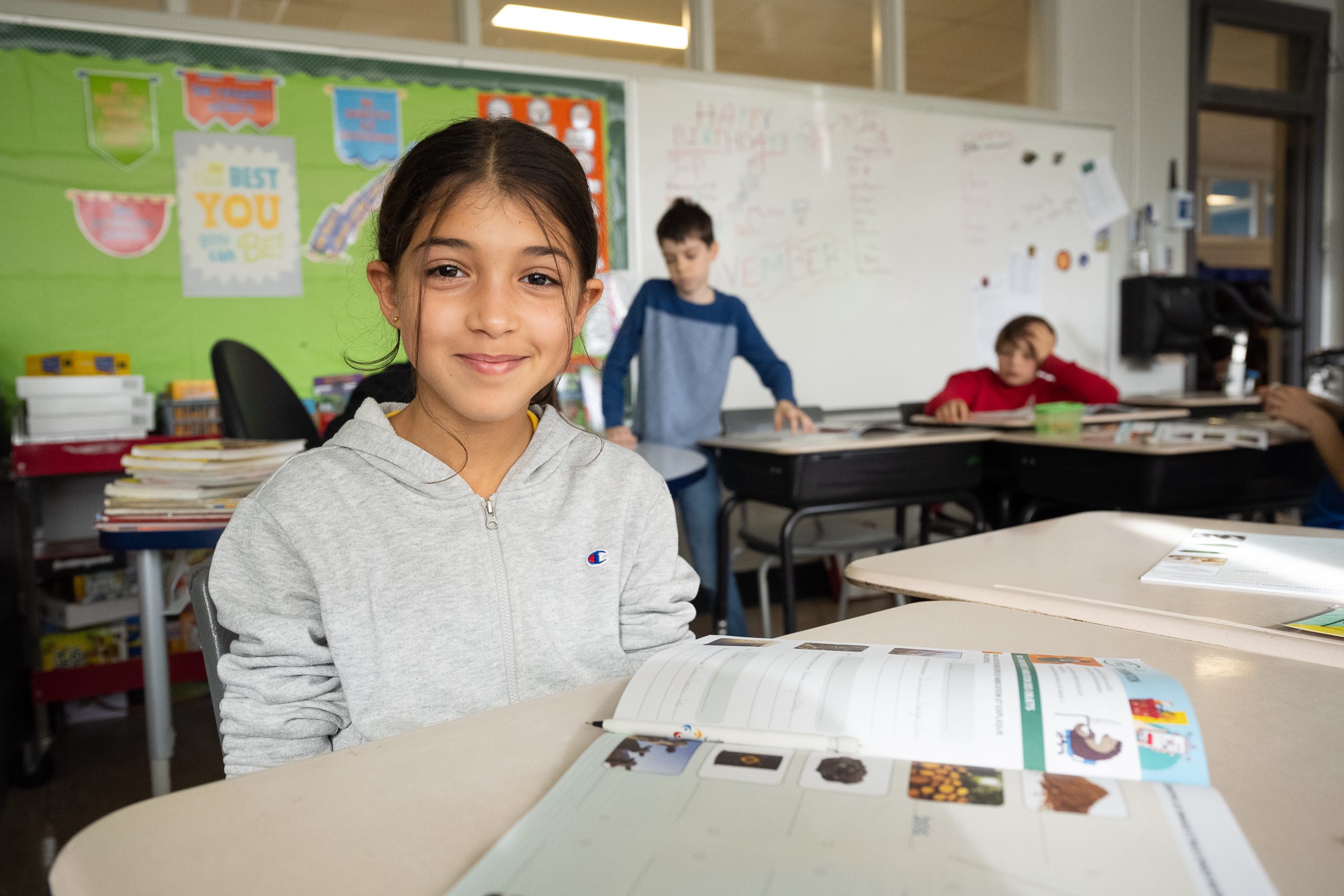 Élève souriante à son pupitre dans une classe du primaire au Québec