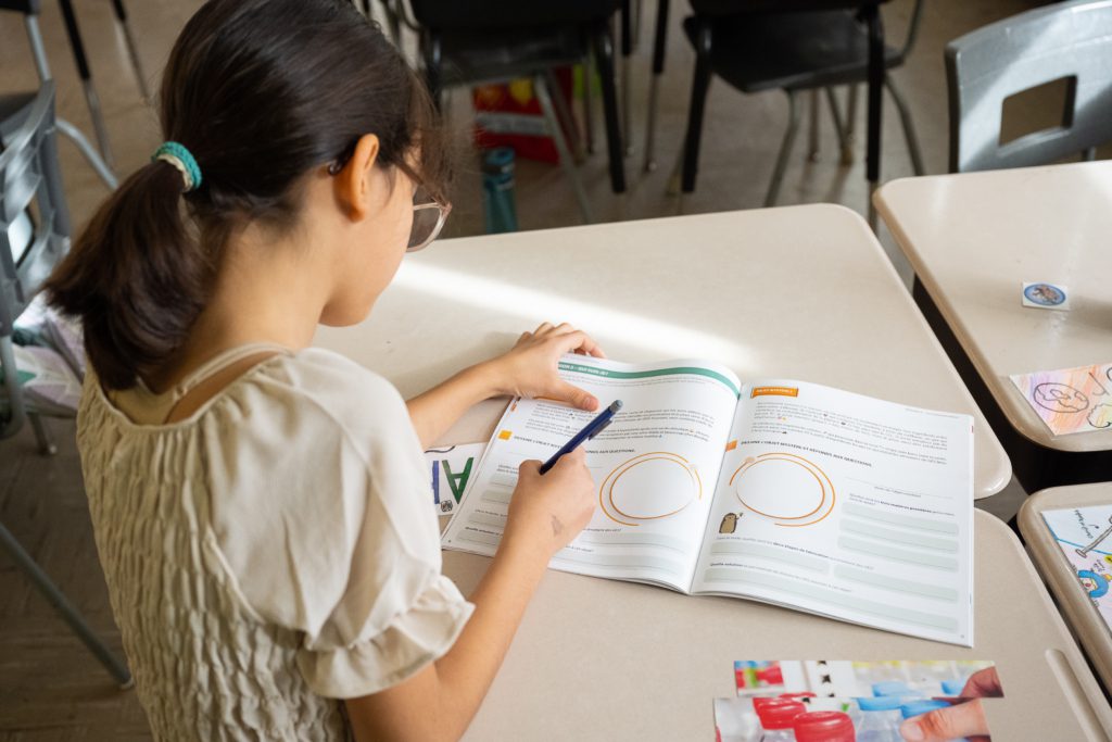 Élève remplissant son cahier d'activités Carbone Scol'ERE en classe